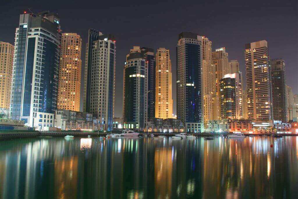 Marina and skyscrapers at night in Dubai, United Arab Emirates.